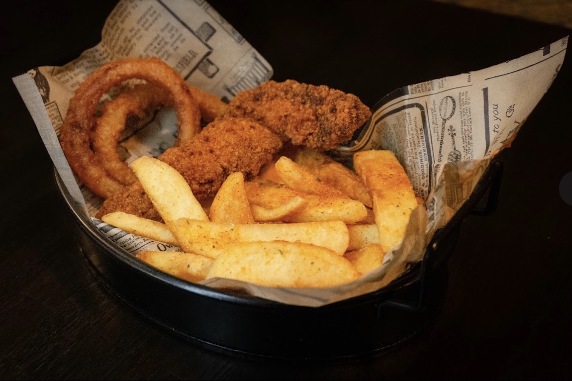 Zwiebelringe, Chicken Tenders und Pommes im Körbchen